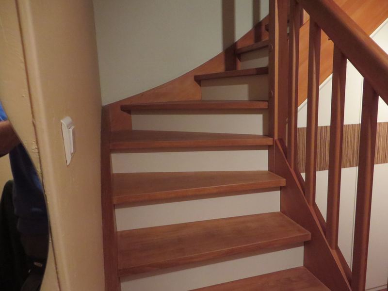 Escalier quart tournant en bois teinté brun-rouge, contremarches blanches, rampe et balustres bois